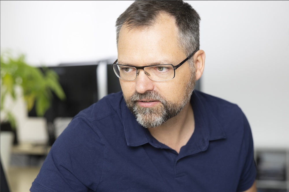 Marcus Wöpe arbeitet konzentriert am Computer an SEO- und Weblösungen - azoora Webagentur mit Spezialisierung auf Suchmaschinenoptimierung und Optimierung für generative Arbeitssysteme