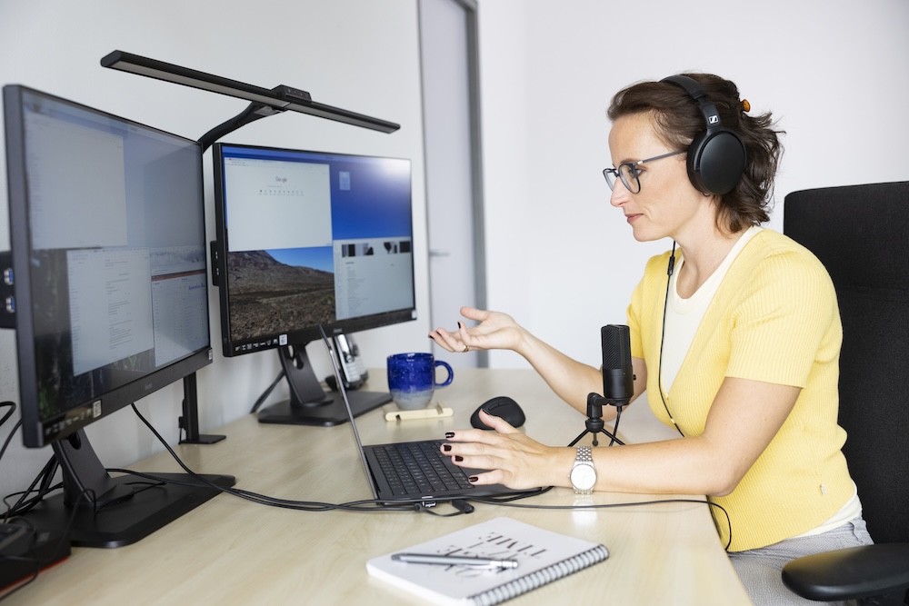 Ramona Wöpe bei der SEO-Analyse mit zwei Monitoren un MacBook im Büro - azoora Webagentur mit Spezialisierung auf Suchmaschinenoptimierung und Optimierung für generative Arbeitssysteme